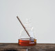 This adorable glass beehive is purposeful about storing and dispensing honey with the accompanying unfinished wood dipper. Natural beehive shape is realized in clear glass with a ringed dipper designed for controlled drizzling